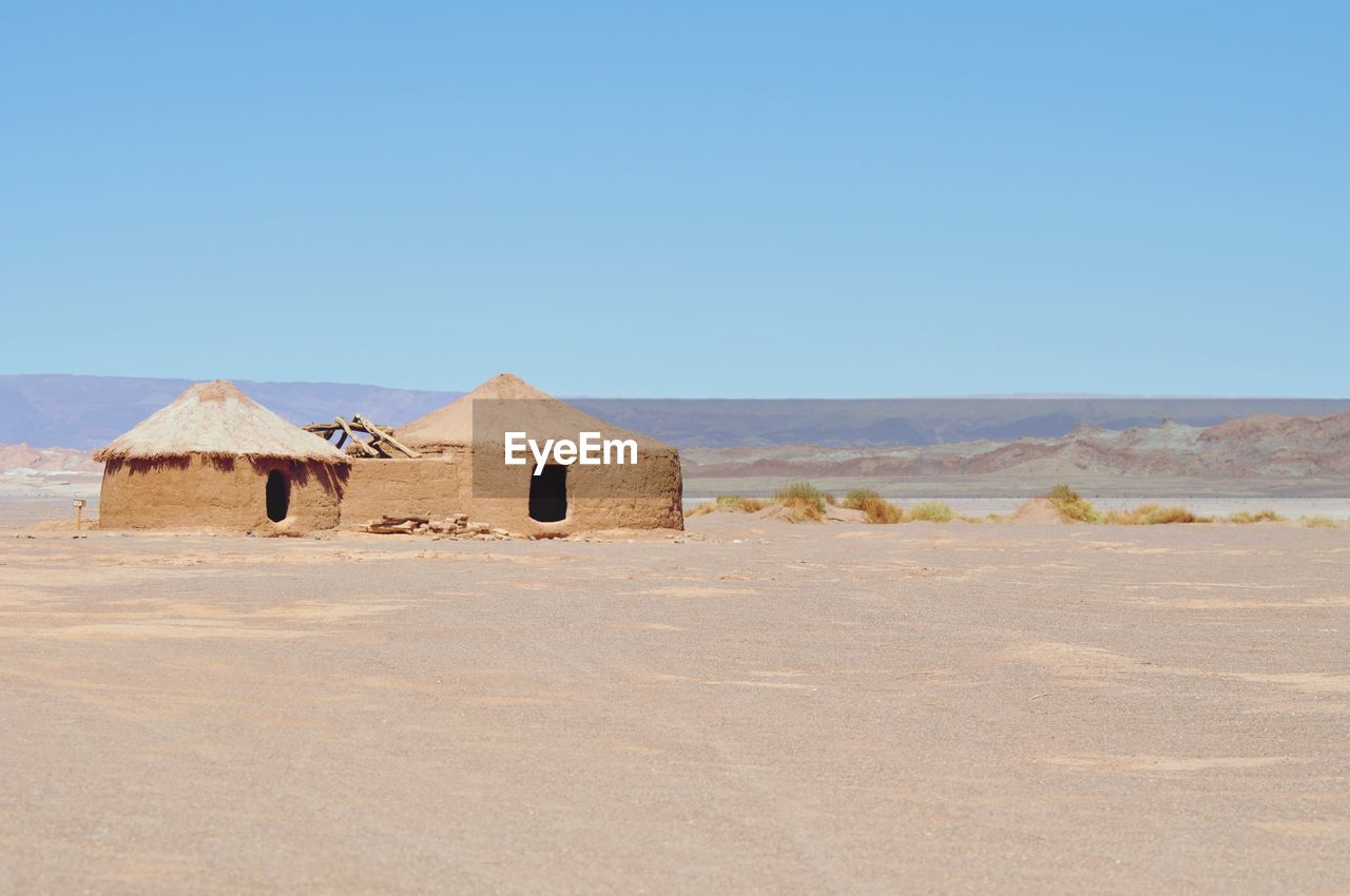 Built structure on desert against clear blue sky