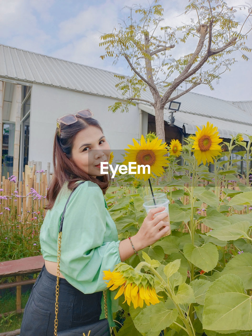 Portrait of young woman standing amidst flowers