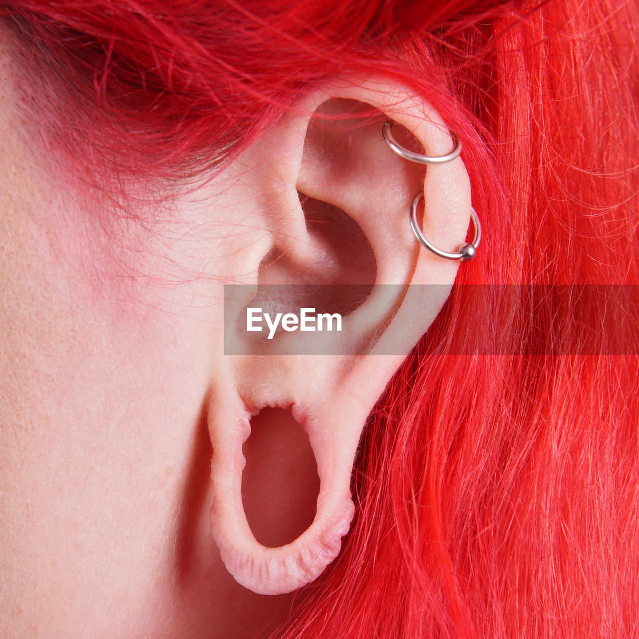 Cropped image of woman with pierced ear and dyed hair