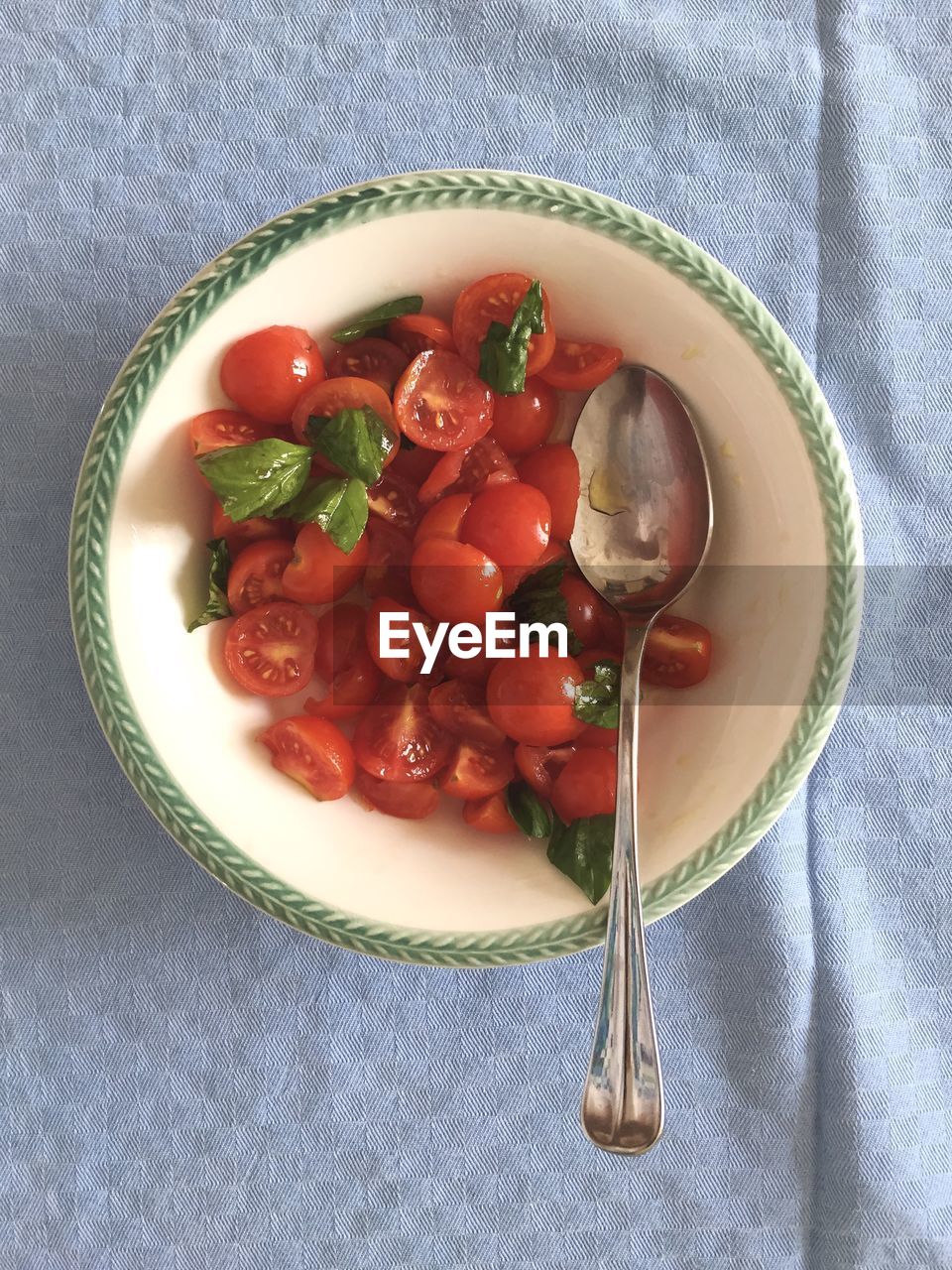 Directly above shot of tomato slices with spoon in bowl