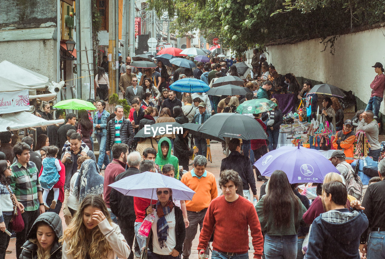 PEOPLE WALKING ON STREET IN RAIN