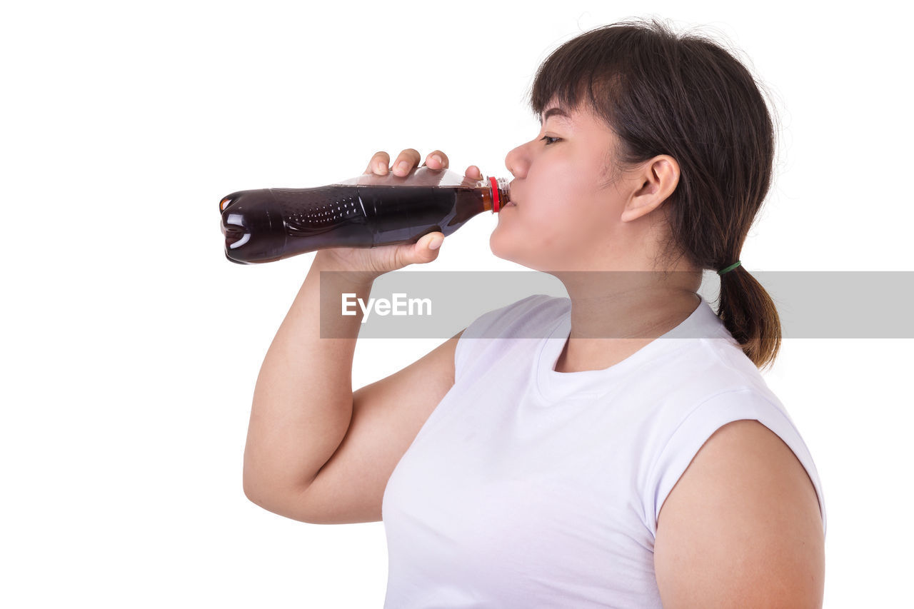 SIDE VIEW OF YOUNG MAN DRINKING GLASS