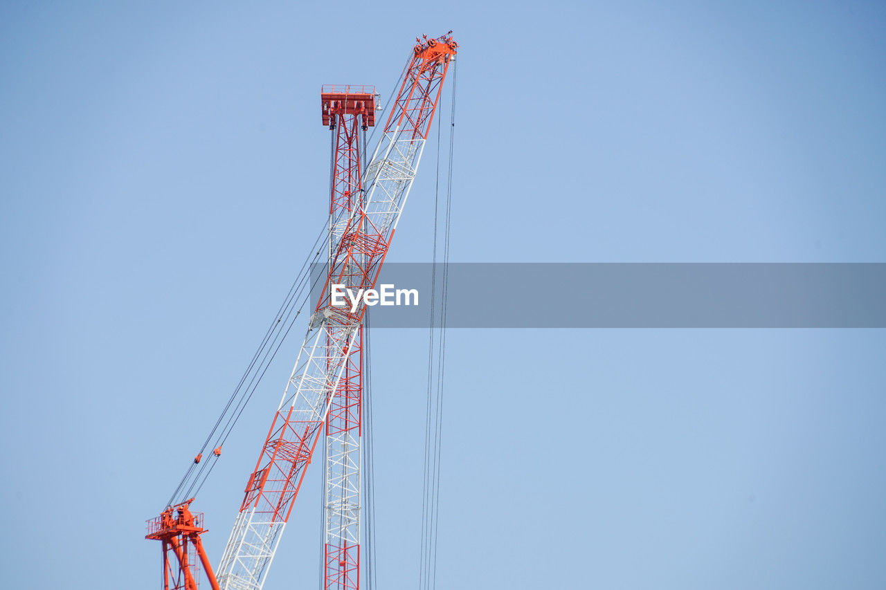 low angle view of cranes against clear sky