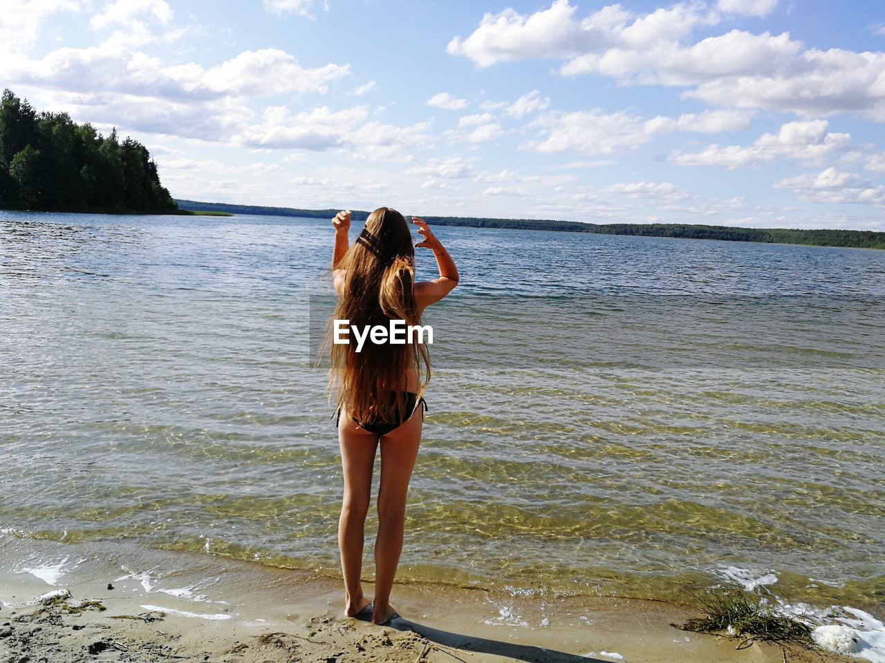 Rear view full length of girl standing on shore at beach