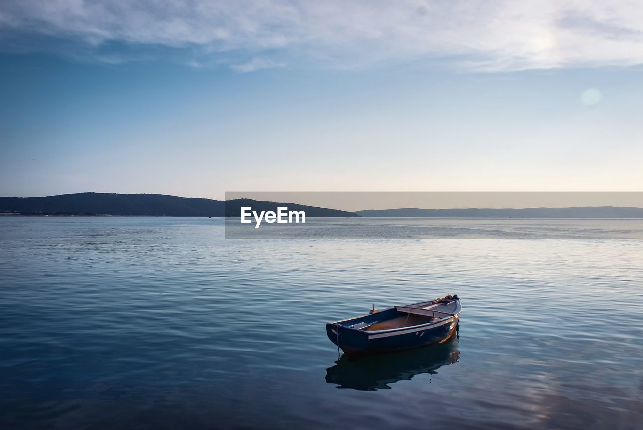 Boat moored on sea against sky