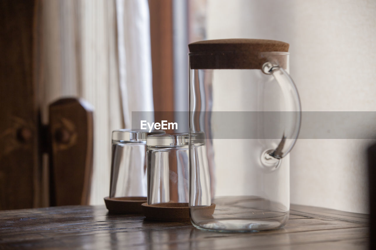 Close-up of drinking glasses with jug on table