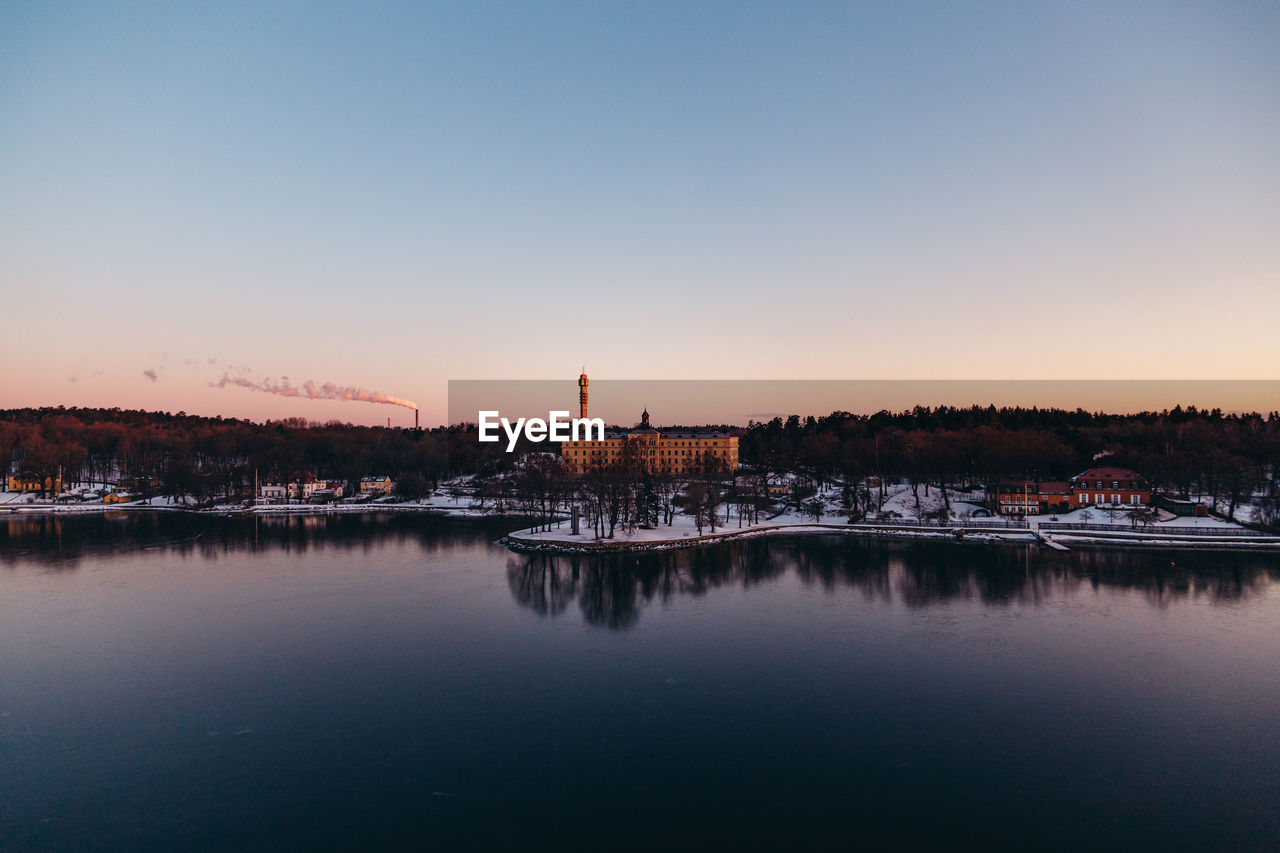 SCENIC VIEW OF LAKE AGAINST SKY AT SUNSET