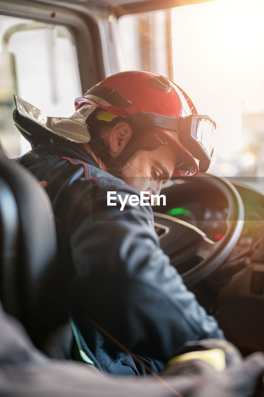 rear view of man wearing hat standing in car