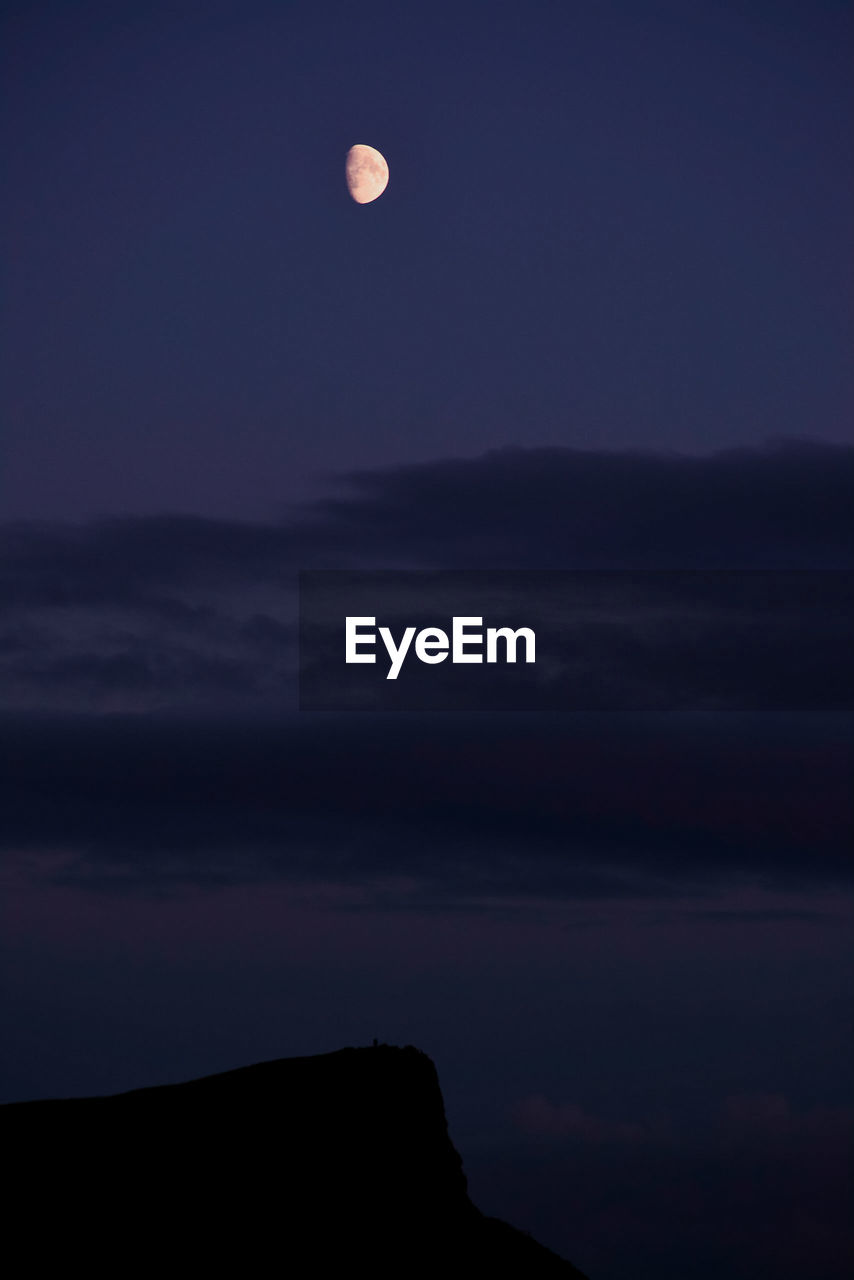 LOW ANGLE VIEW OF MOON AGAINST SKY AT SUNSET