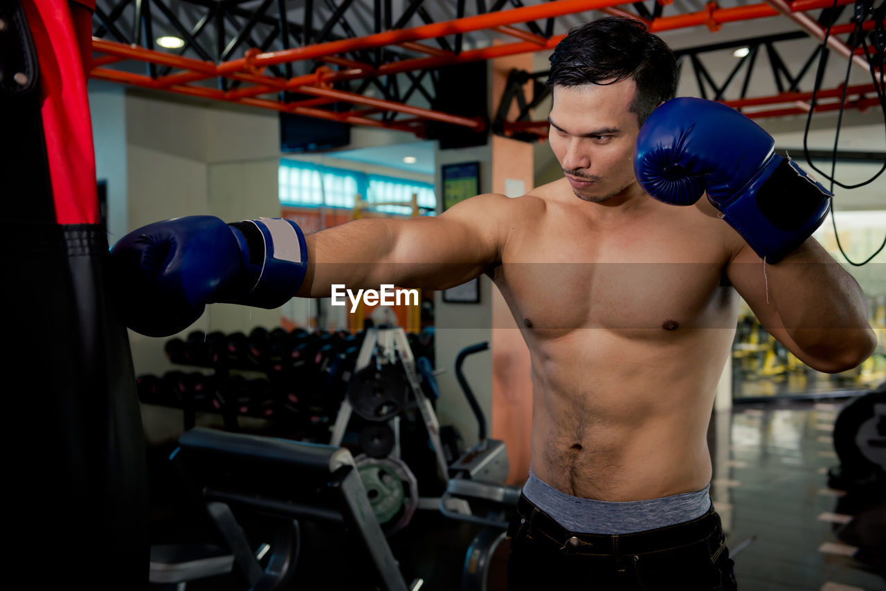 Shirtless muscular man exercising at gym