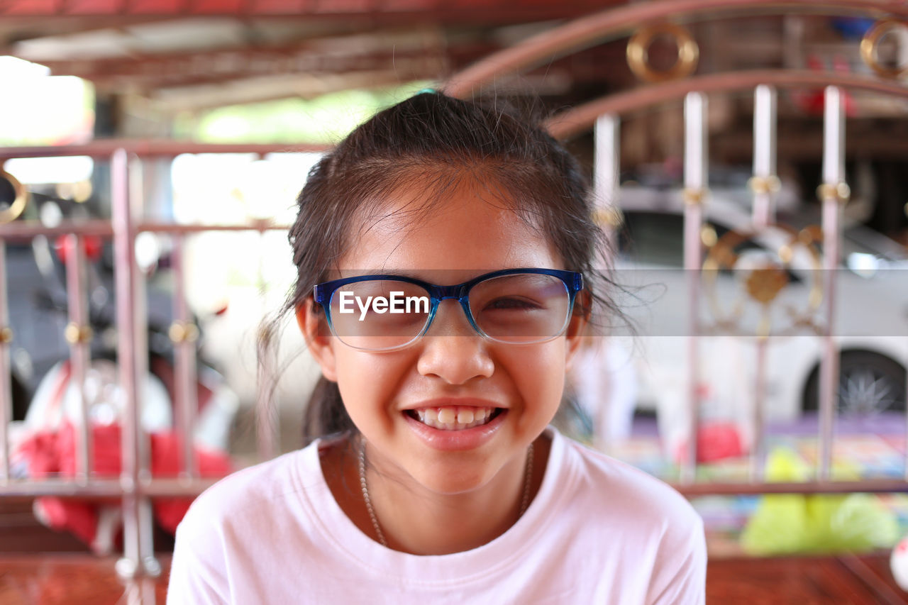 portrait of young woman wearing sunglasses while sitting at cafe