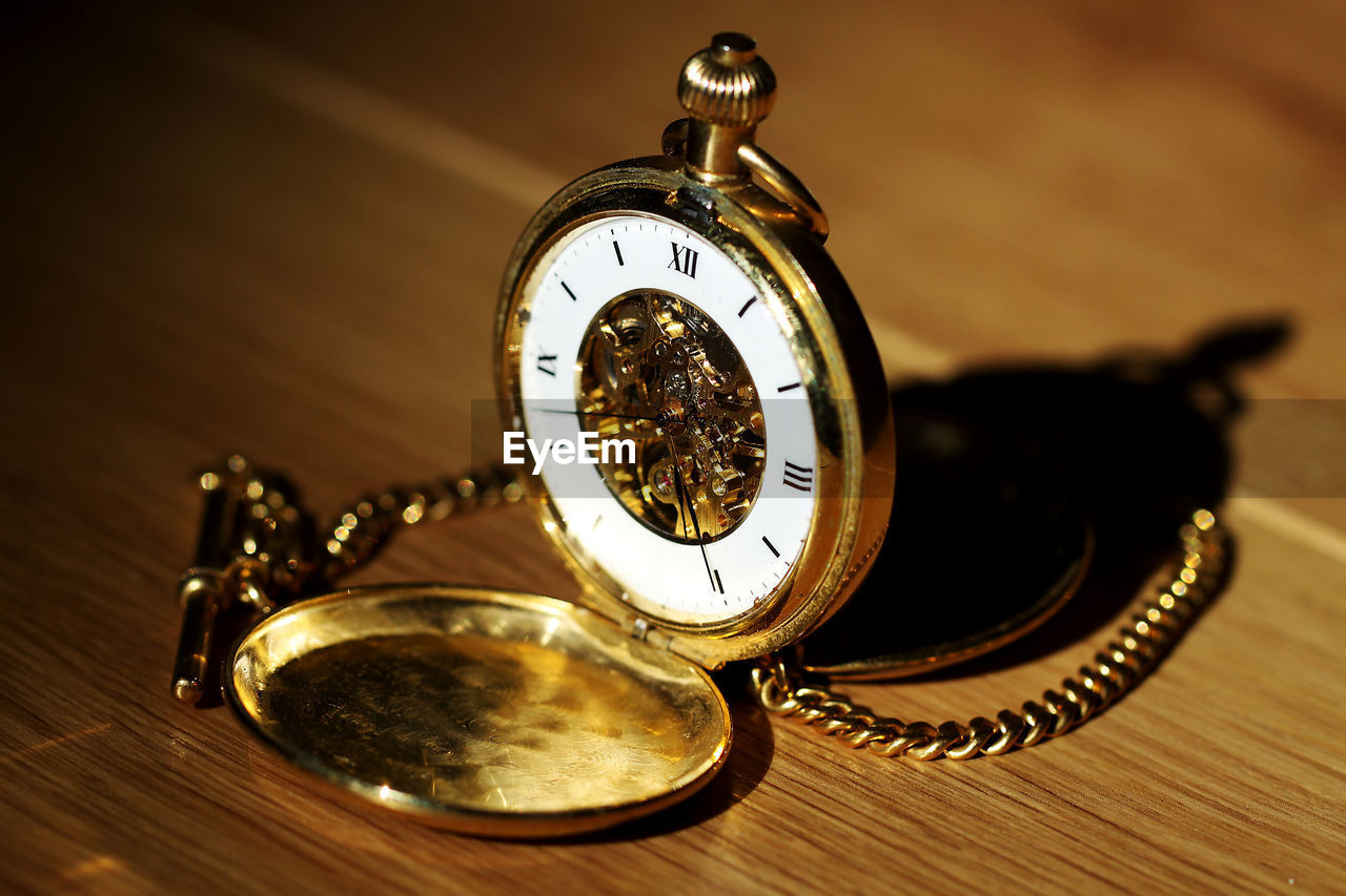 Close-up of pocket watch on table