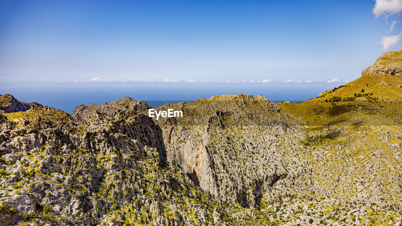PANORAMIC VIEW OF ROCKS AND MOUNTAINS AGAINST SKY