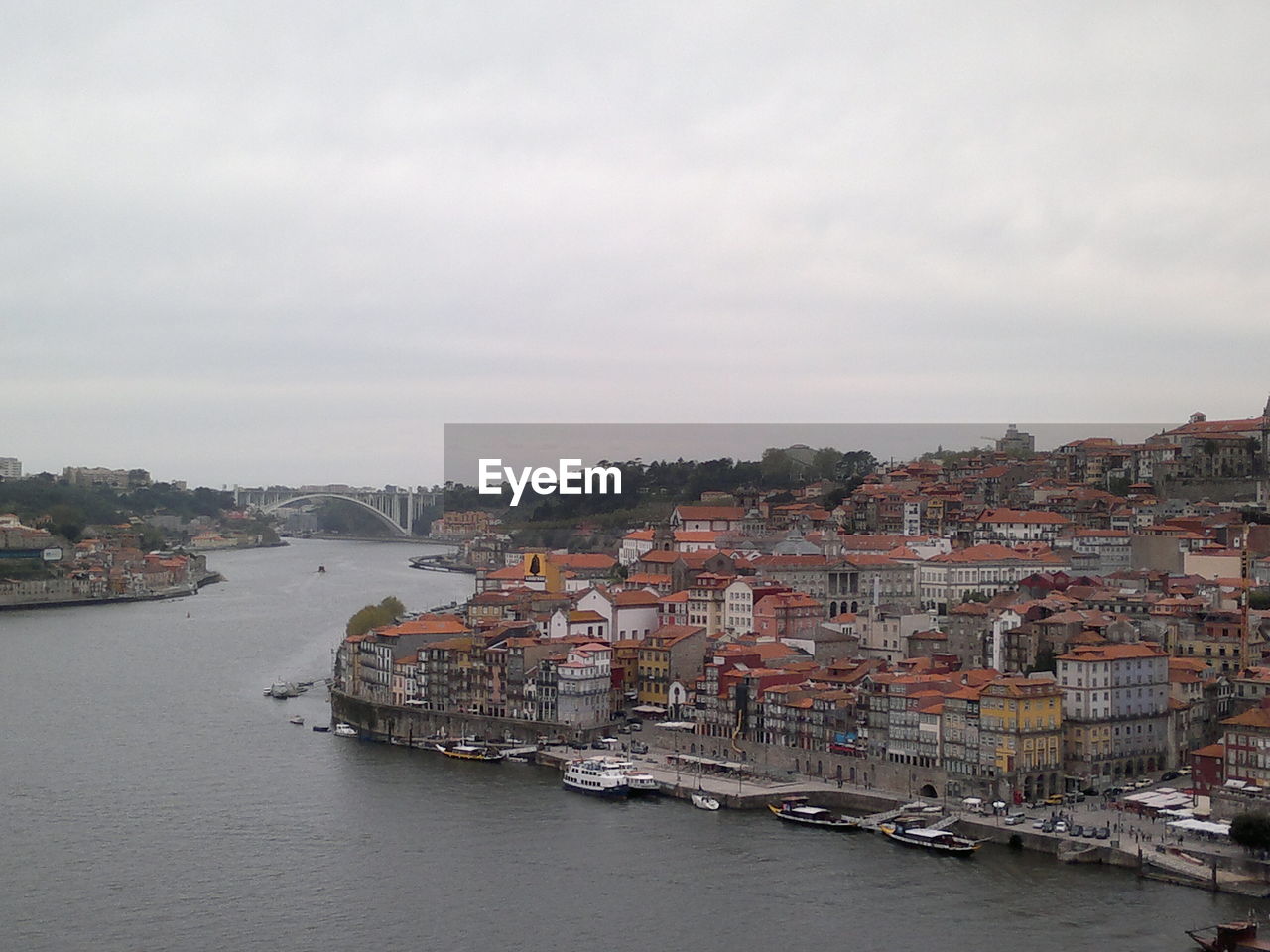 BOATS IN RIVER WITH CITYSCAPE IN BACKGROUND