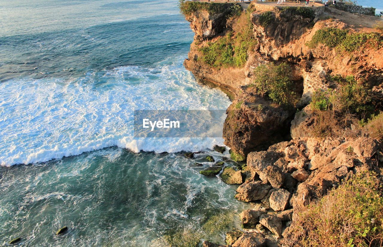 Wave hitting on the rock portrait from above the cliff