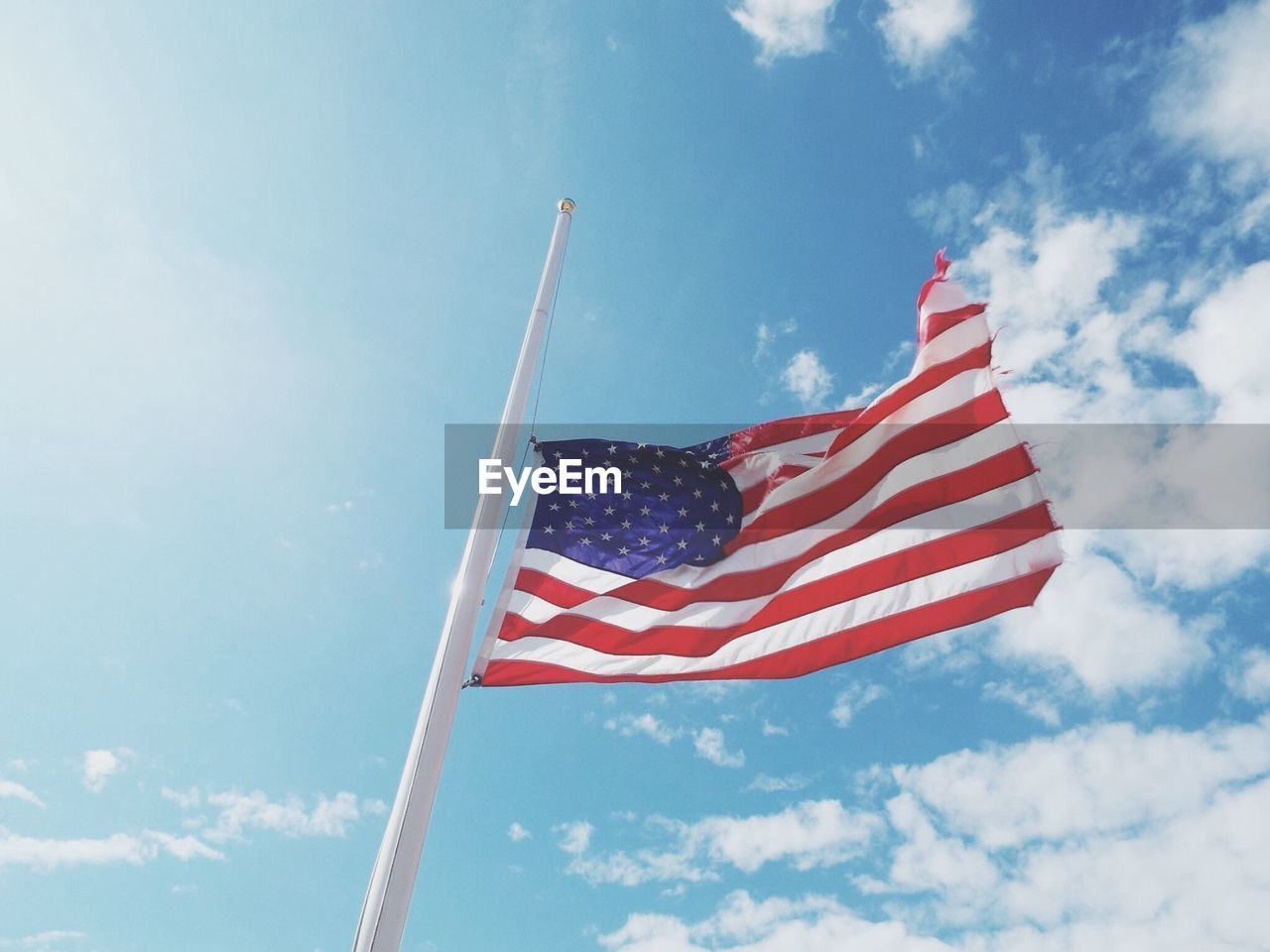 Low angle view of american flag against cloudy sky