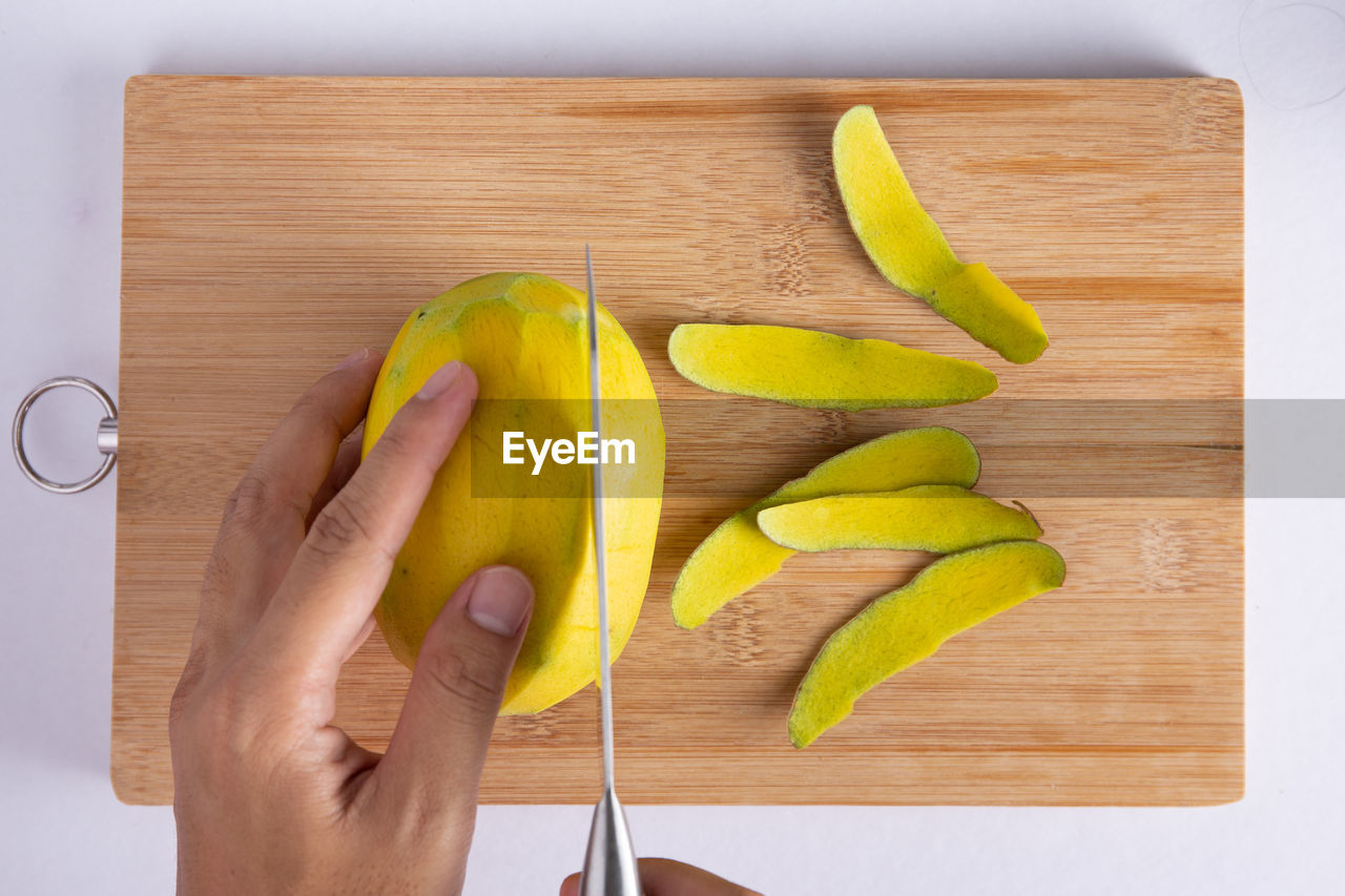 Cutting mango fruit on wood