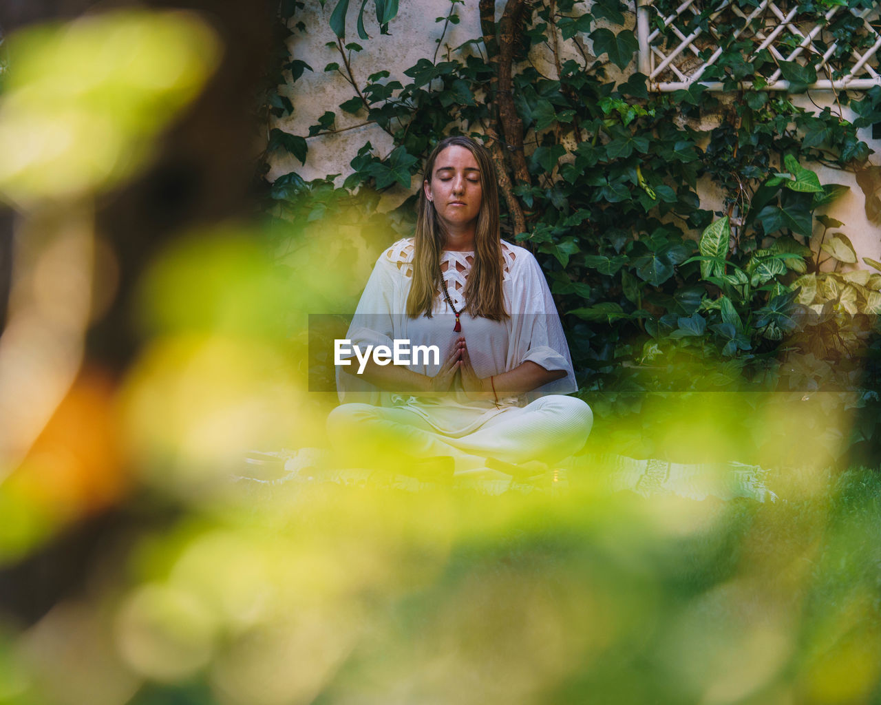 PORTRAIT OF BEAUTIFUL WOMAN SITTING OUTDOORS