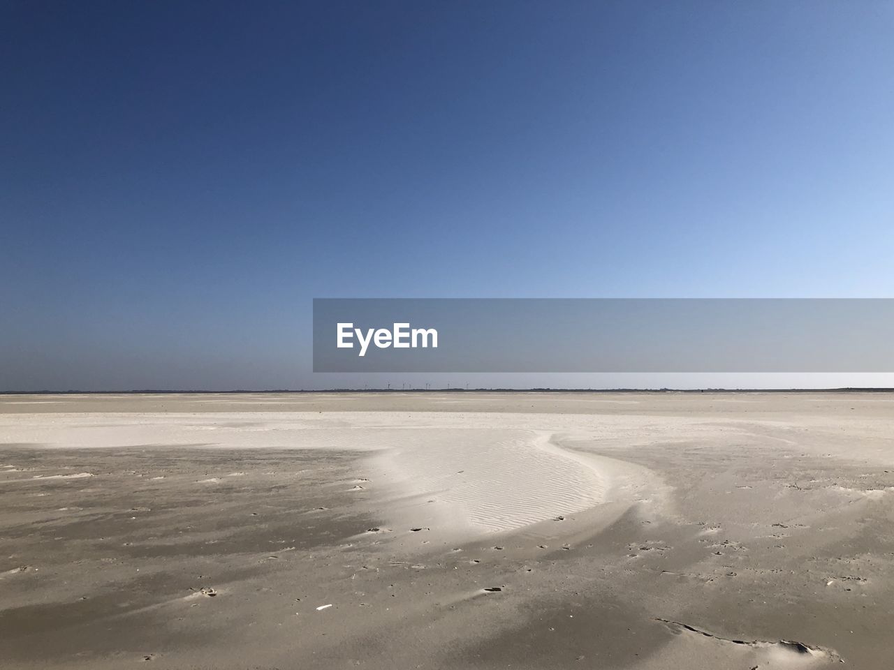 Scenic view of desert against clear blue sky