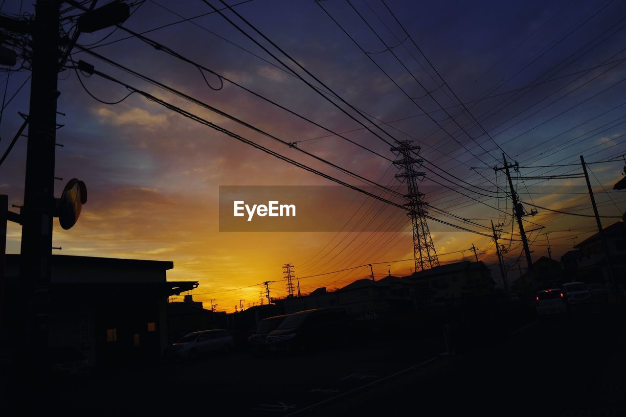 LOW ANGLE VIEW OF POWER LINES AGAINST DRAMATIC SKY