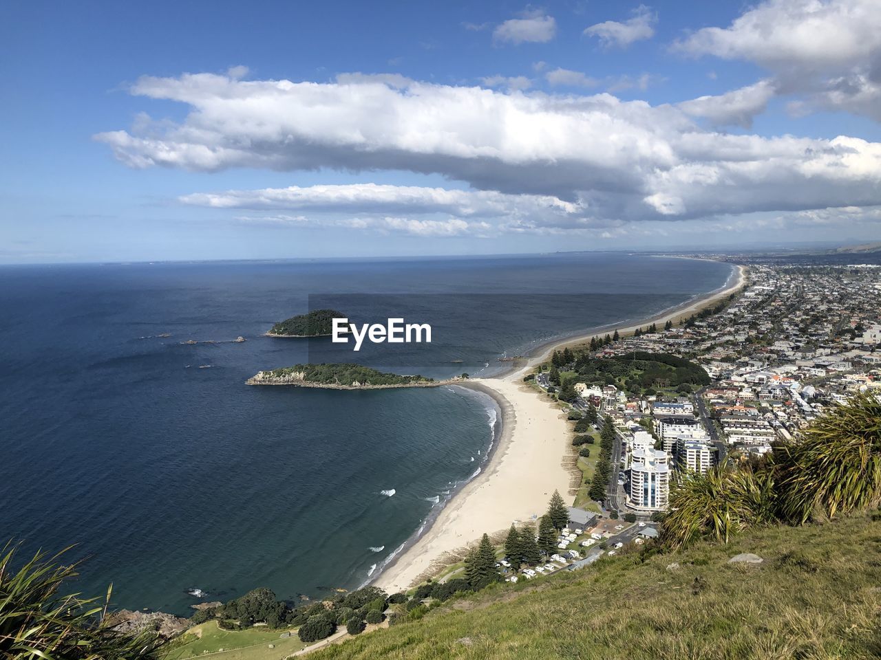 High angle view of city by sea against sky