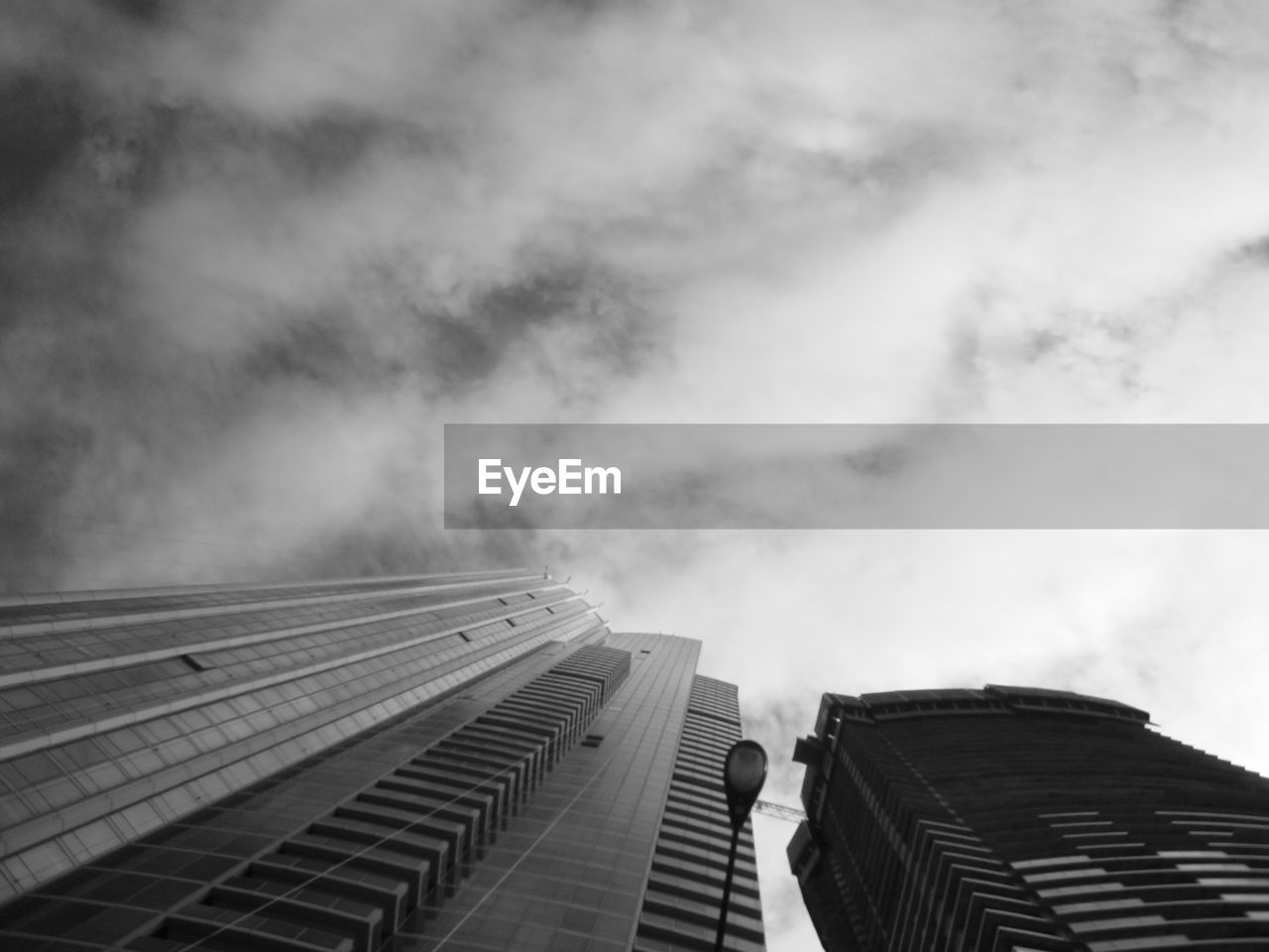 Low angle view of tall buildings against clouds