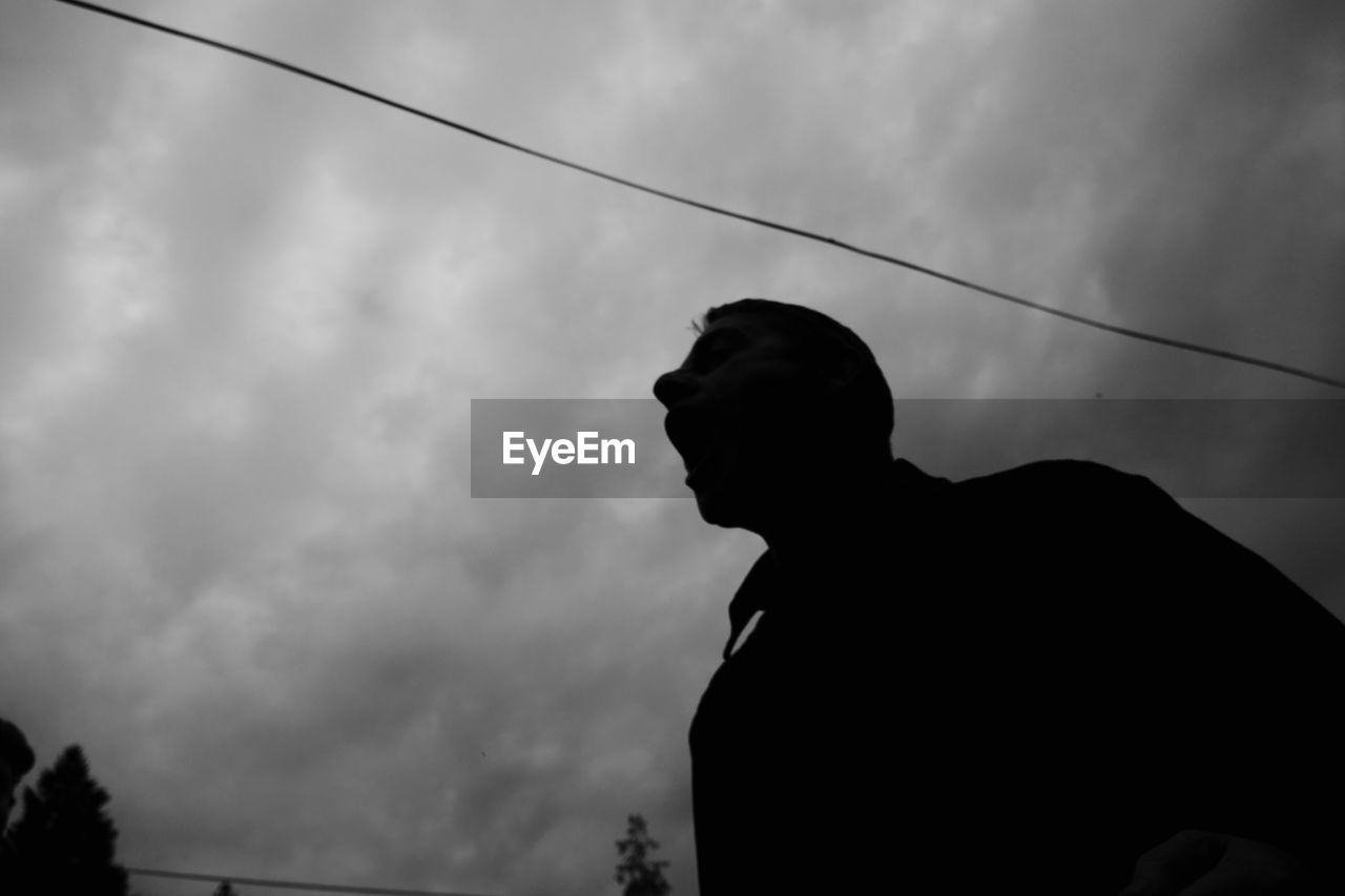 Low angle view of silhouette man against sky