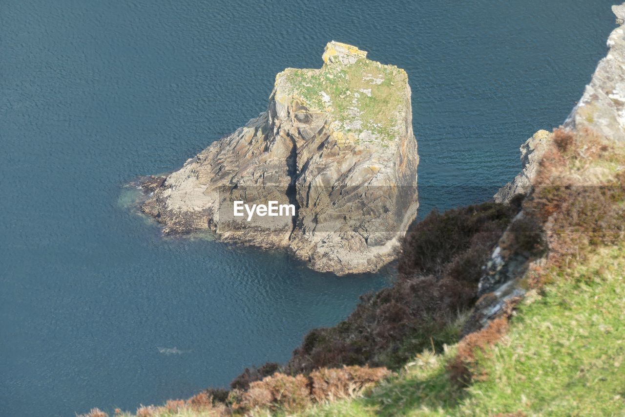 water, sea, cliff, nature, terrain, rock, beauty in nature, land, no people, scenics - nature, high angle view, coast, tranquility, day, beach, rock formation, tranquil scene, plant, geology, outdoors, non-urban scene, coastline, bay, sunlight, travel destinations, blue, idyllic