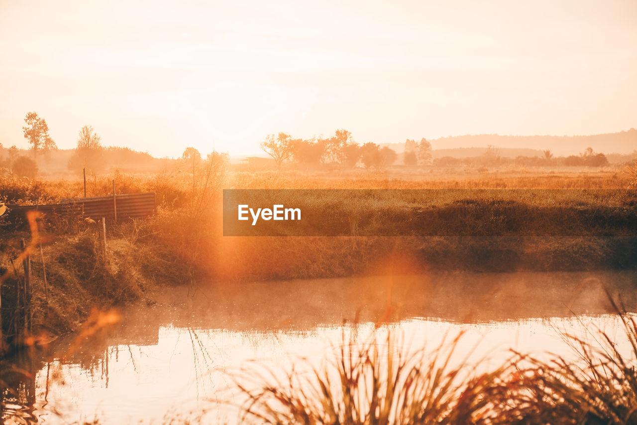 Scenic view of lake against sky during sunset