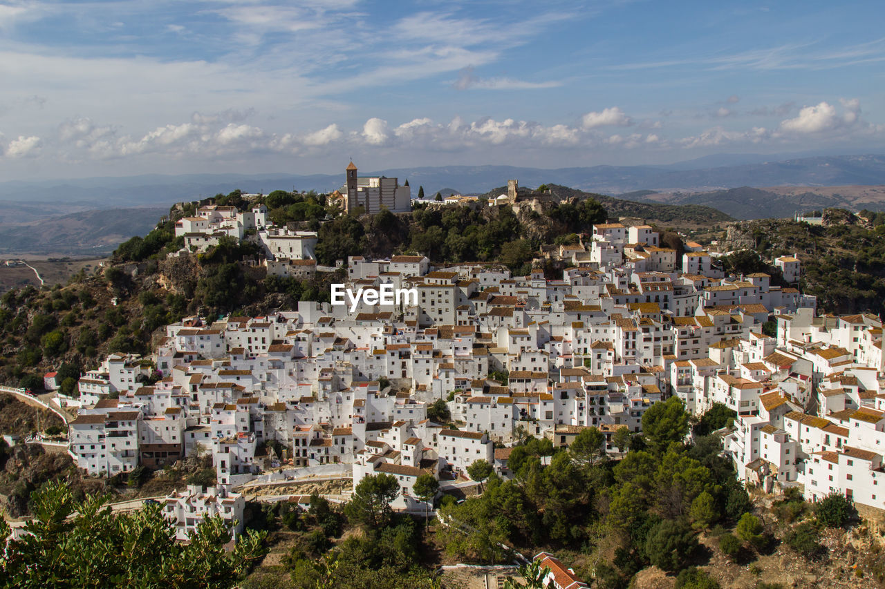 High angle view of cityscape against cloudy sky