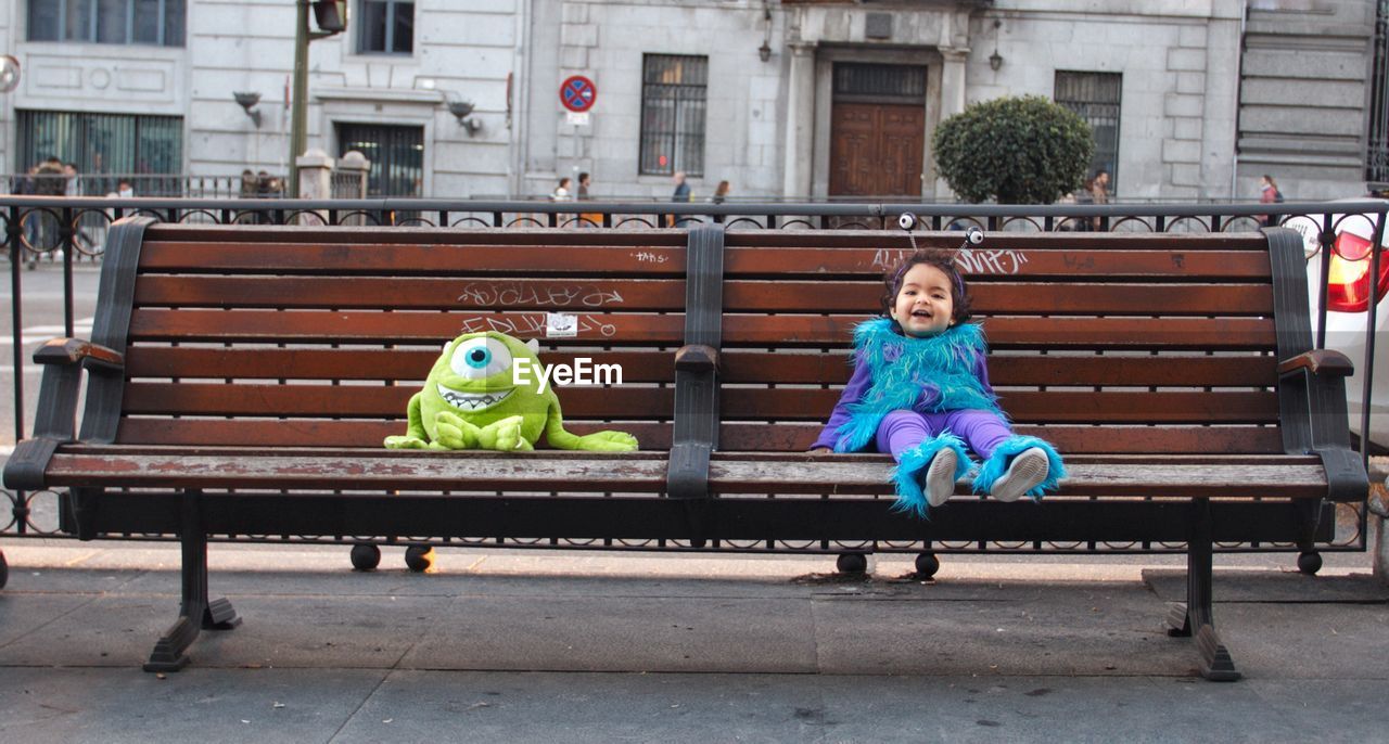 BOY SITTING ON BENCH IN PARK