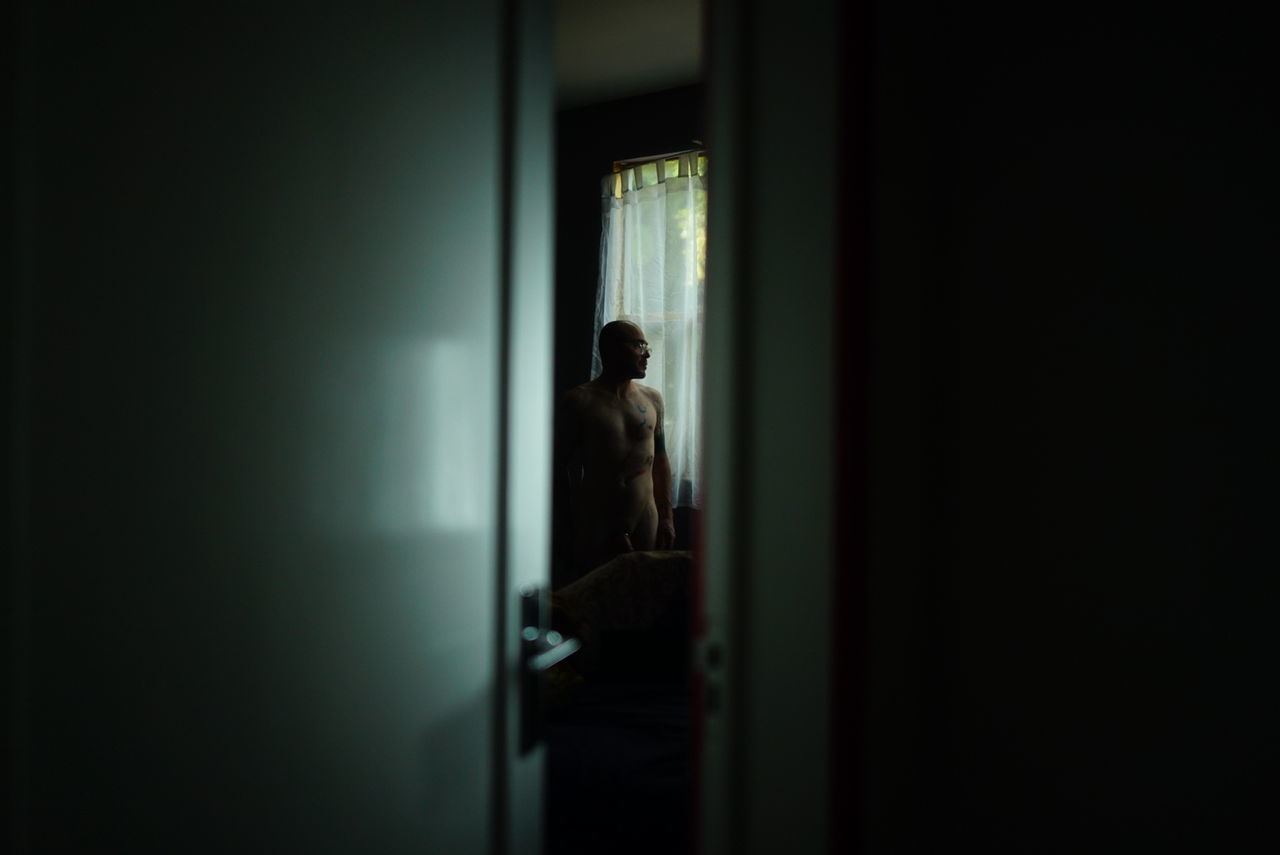 darkness, light, black, indoors, one person, door, entrance, dark, adult, loneliness, standing, solitude, doorway, arcade, corridor, architecture, copy space, depression - sadness, emotion, women, sadness, night, men, building, lighting, person, window, white, looking, mystery