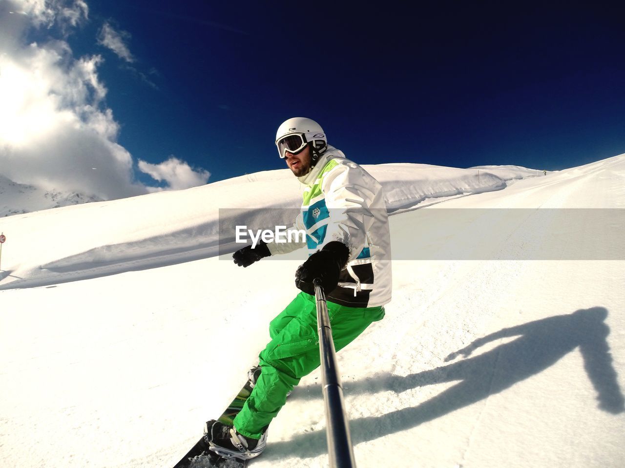 LOW ANGLE VIEW OF WOMAN STANDING AGAINST BLUE SKY