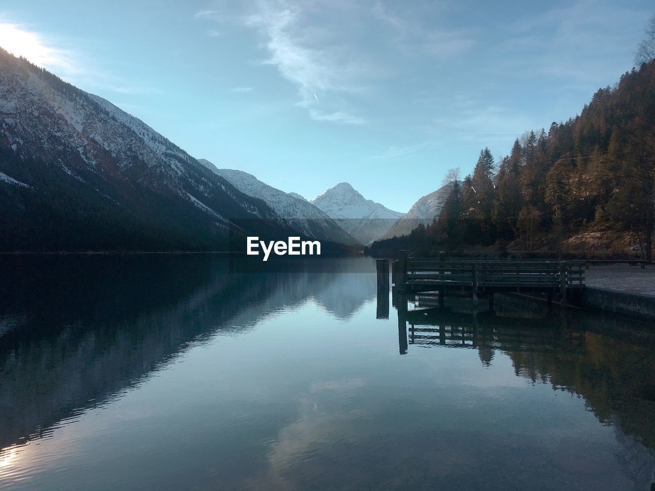 Scenic view of lake by mountains against sky