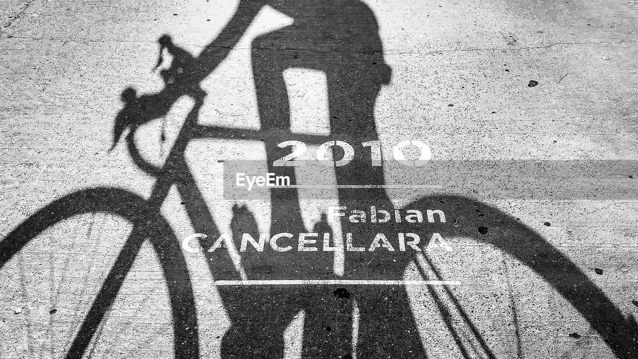 Oude kwaremont, belgium, shadow of a cyclist with fabian cancellara message on the road