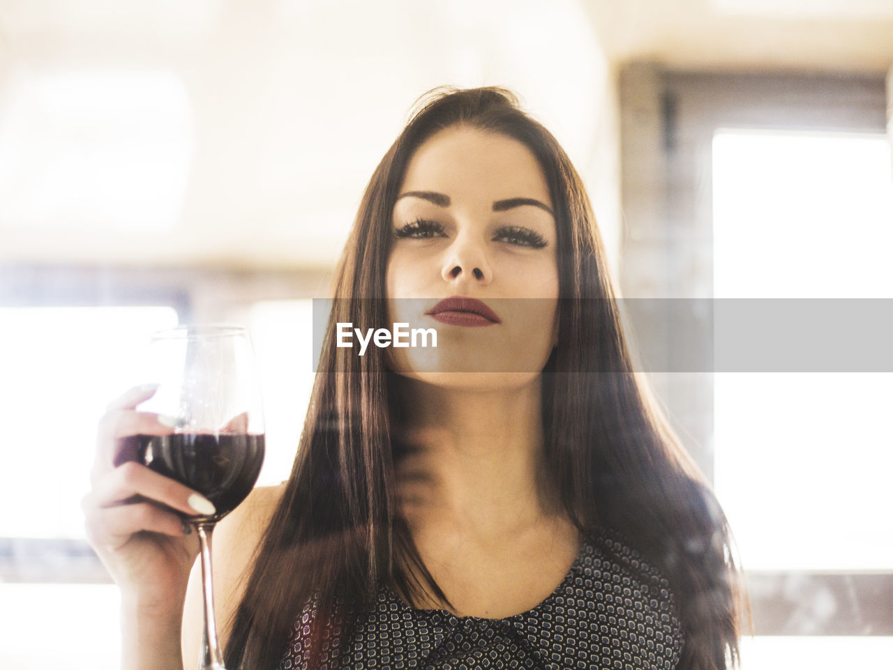 Portrait of beautiful young woman with drinking glass