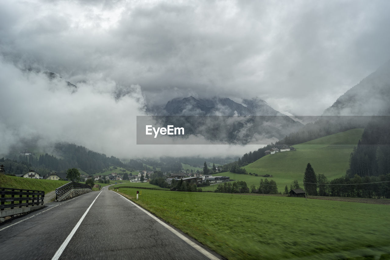 Road by mountains against sky