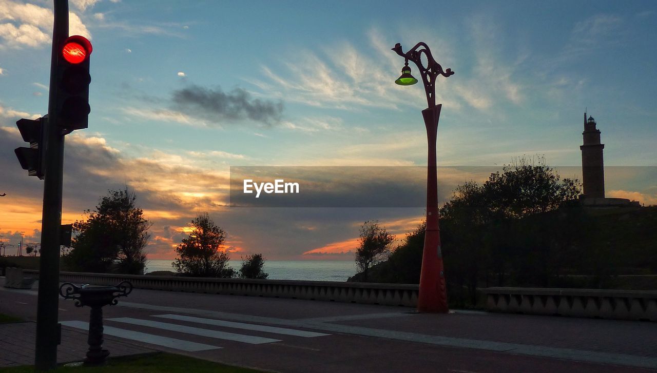 Antique street light on roadside against sunset sky