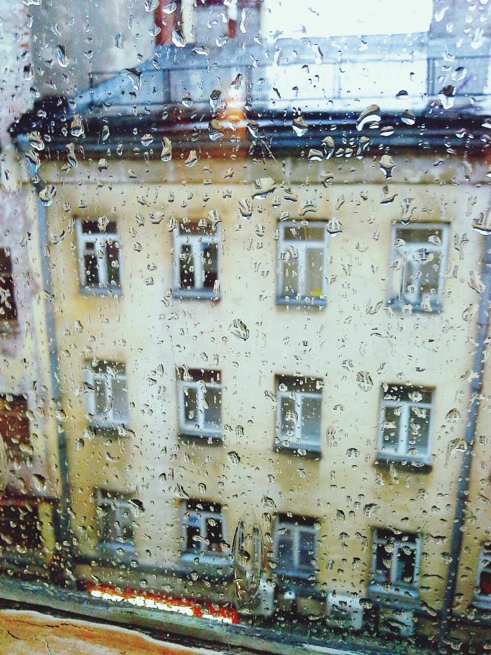 Waterdrops on glass with view of building