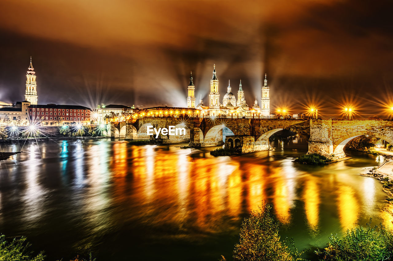 The ebro river at night in zaragoza, spain at the back of the basílica de nuestra señora del pilar