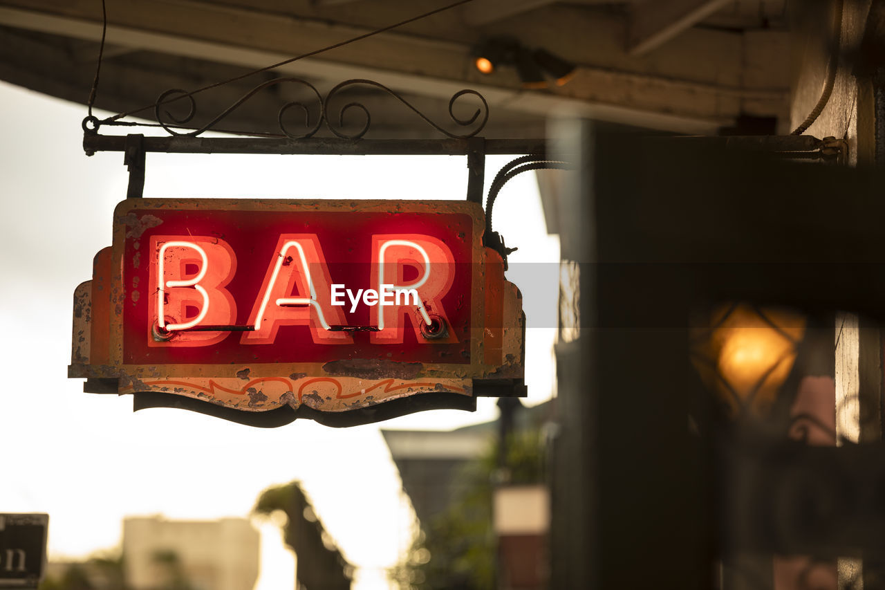 LOW ANGLE VIEW OF ILLUMINATED SIGN AGAINST BUILDING