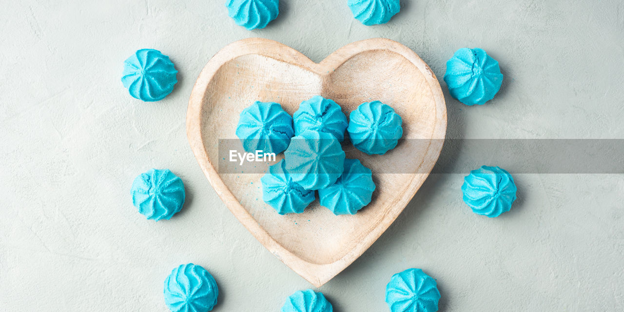 blue, turquoise, heart shape, aqua, petal, teal, love, positive emotion, indoors, no people, creativity, emotion, icing, high angle view, green, sweet food, directly above, food and drink, still life, holiday, studio shot, food, wood, celebration, decoration, sweet, close-up, craft, shape, turquoise colored, cookie, dessert, light blue