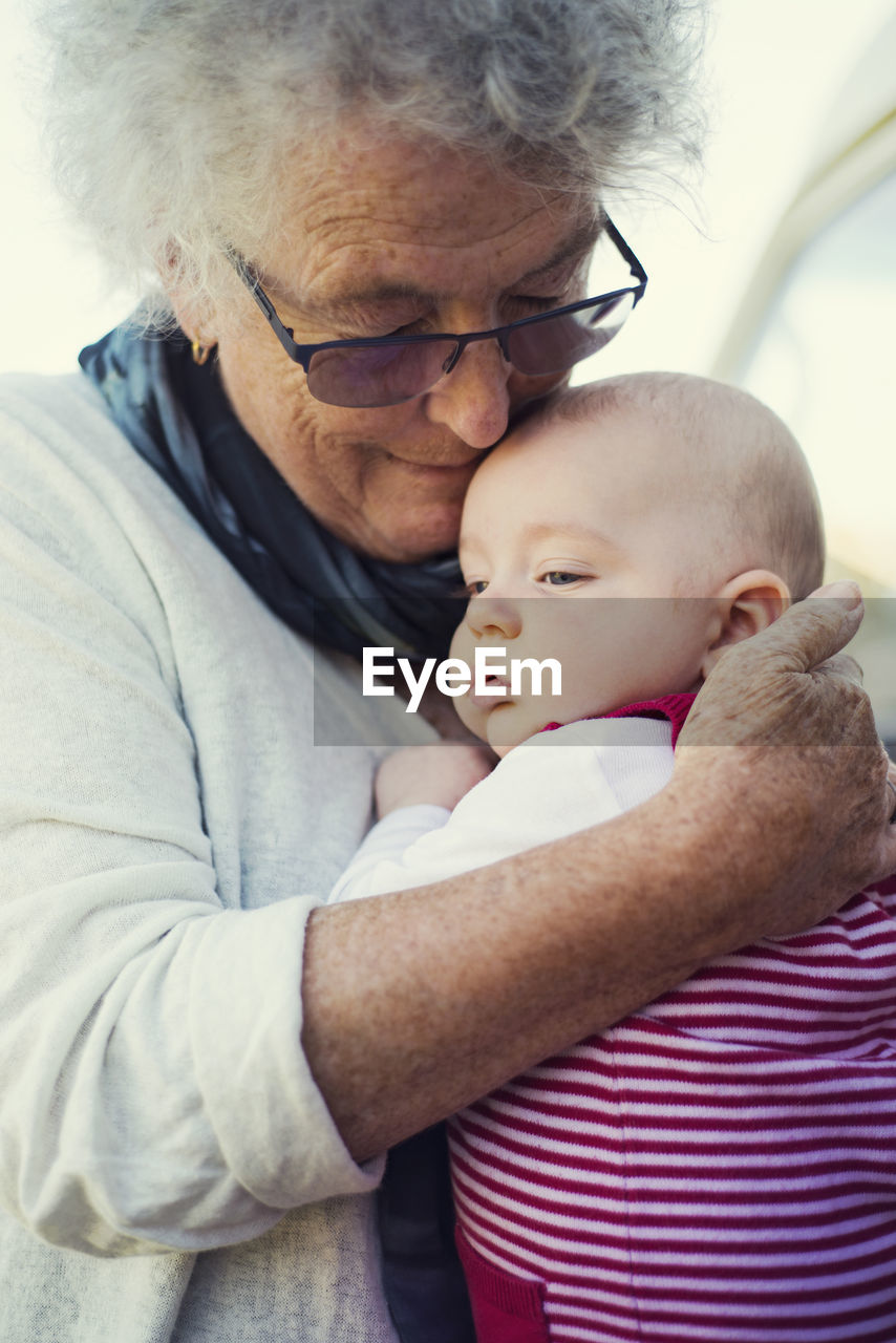 Close-up of grandmother embracing baby boy