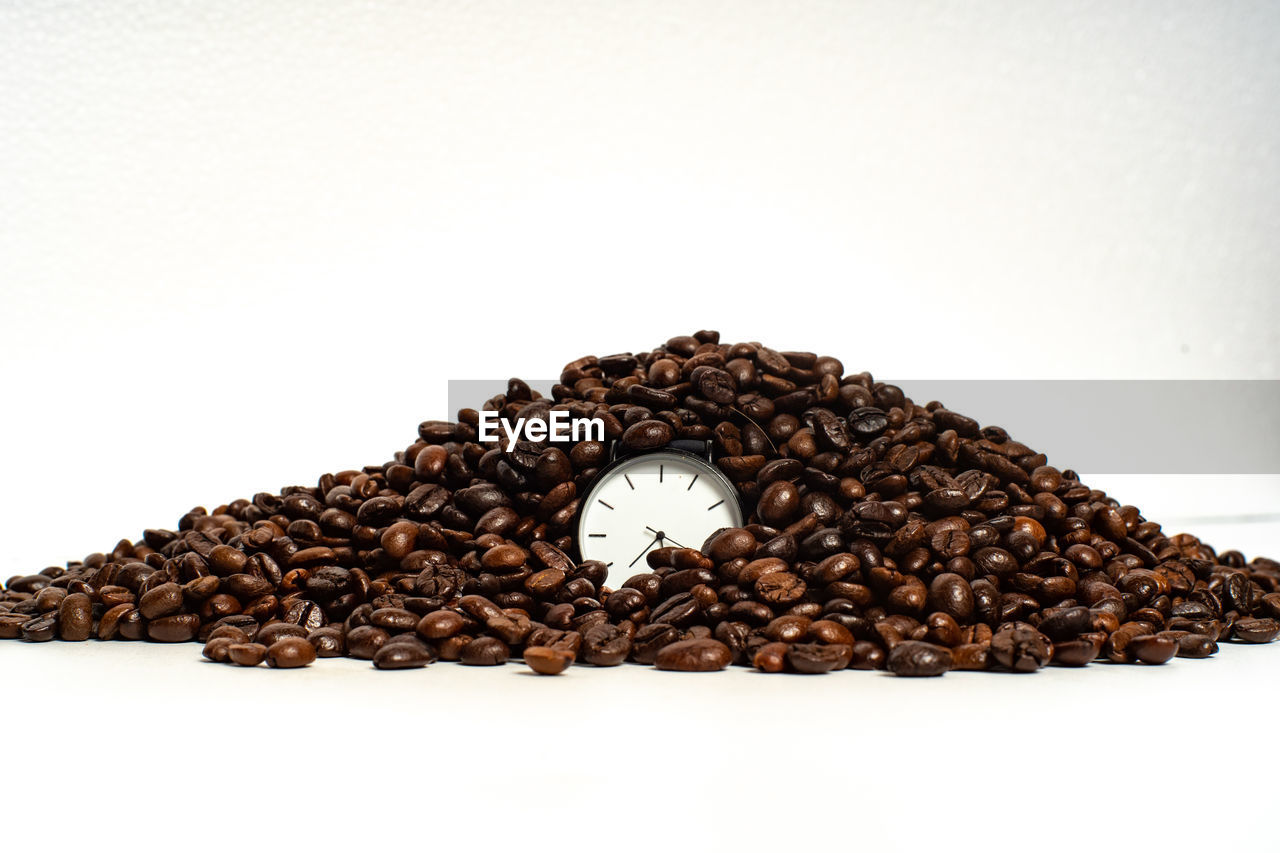 CLOSE-UP OF COFFEE BEANS ON WHITE BACKGROUND