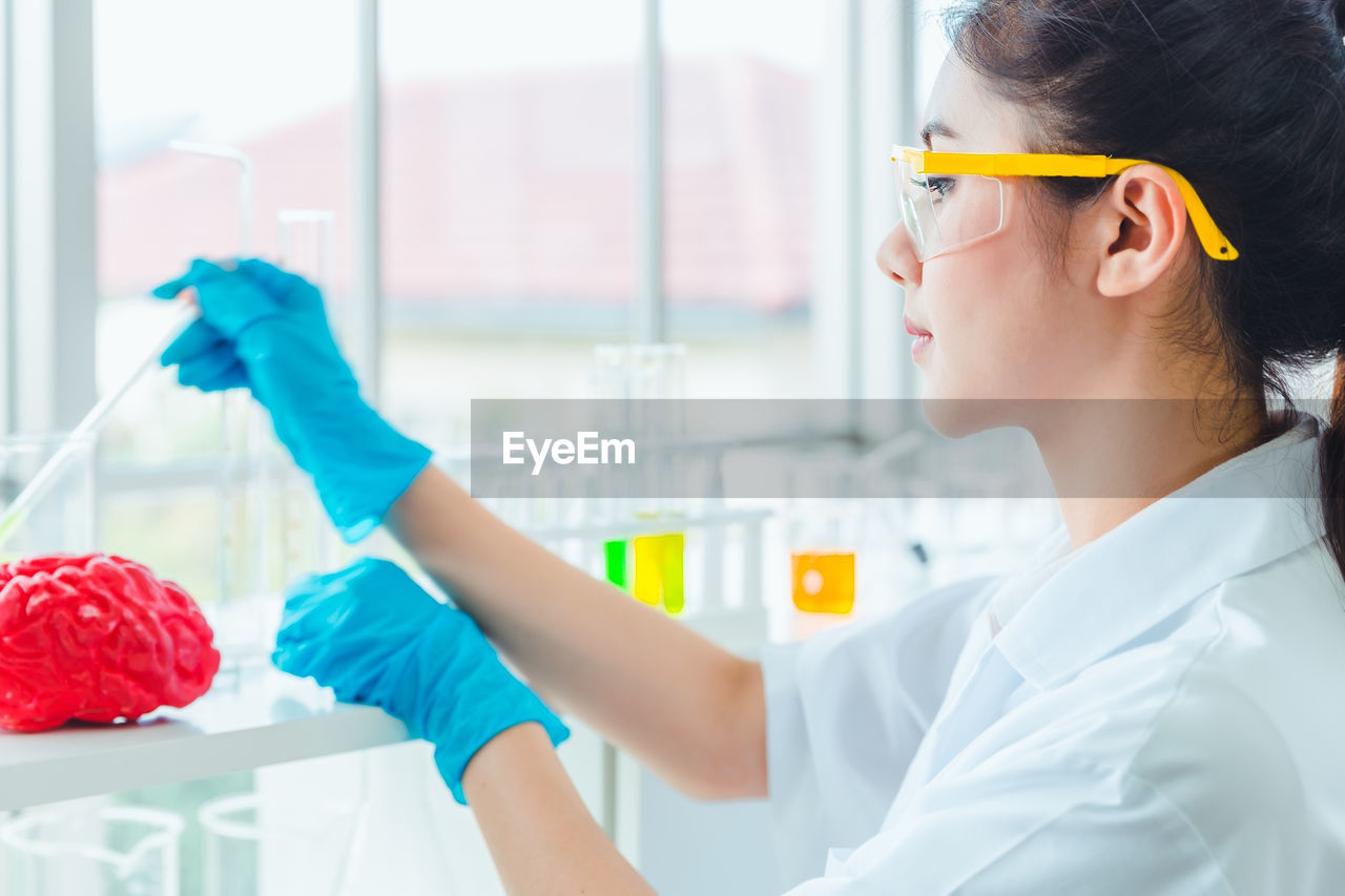 Side view of woman experimenting in laboratory