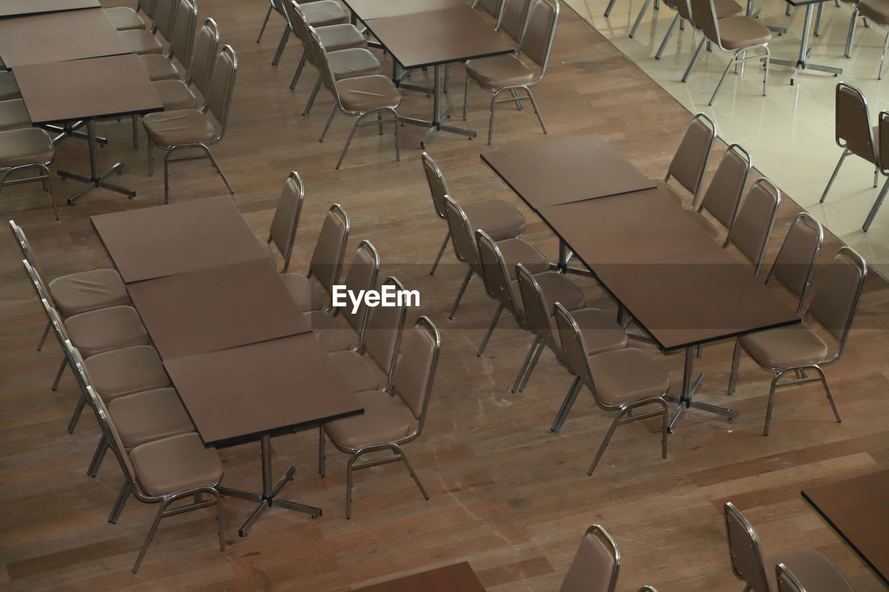 High angle view of empty chairs and tables arranged on hardwood floor