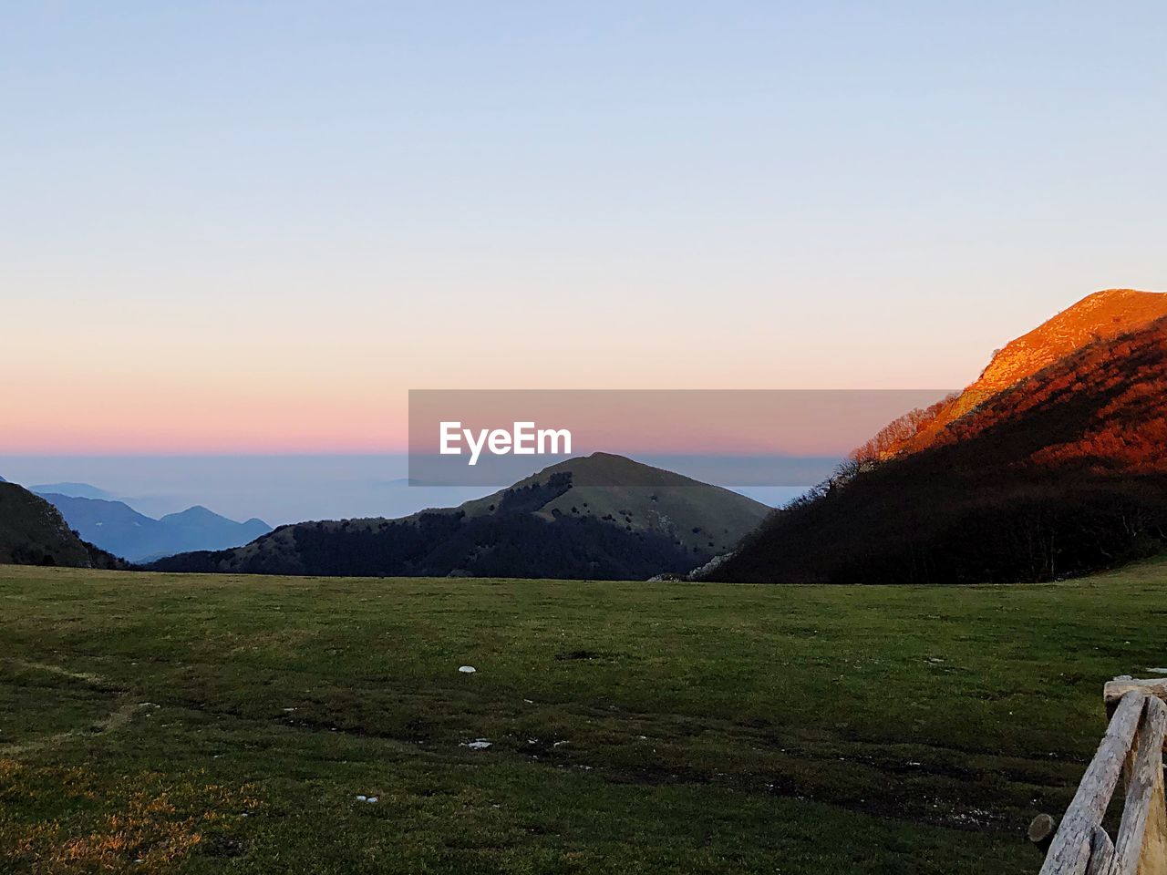 SCENIC VIEW OF LANDSCAPE AND MOUNTAINS AGAINST SKY DURING SUNSET