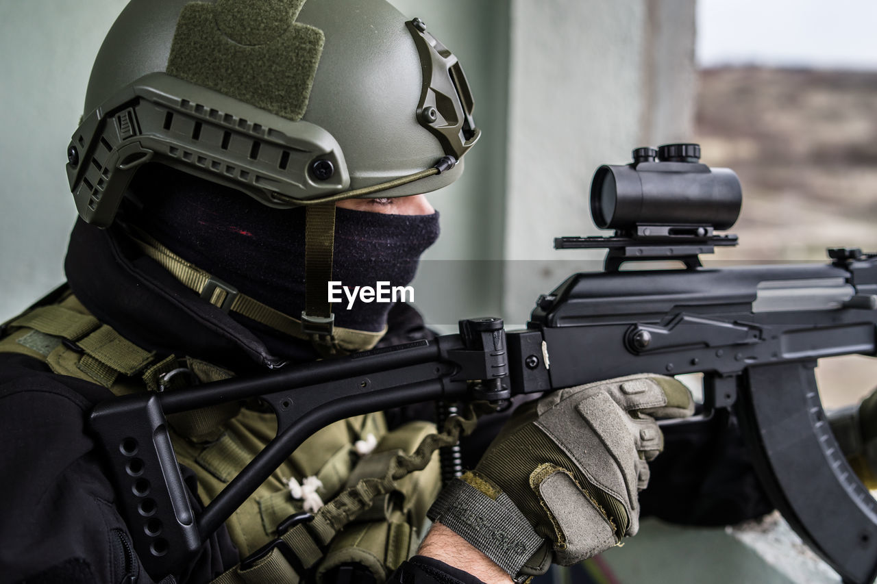 Close-up of army soldier aiming gun