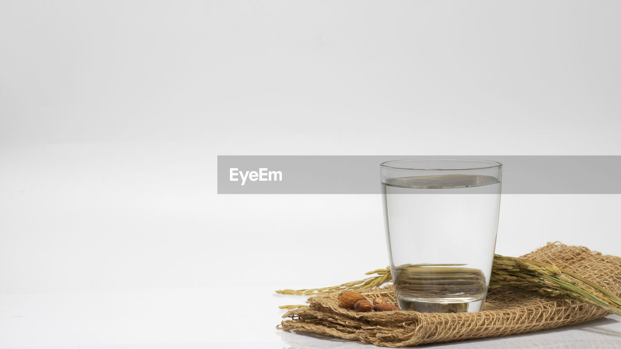 GLASS OF WATER ON WHITE TABLE