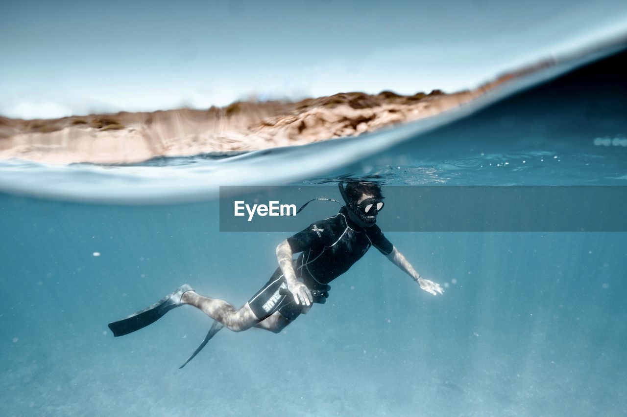 FULL LENGTH OF MAN SWIMMING IN SEA